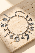 Incanto charm bracelet laid flat on travertine stone showing all 14 antiqued silver charms