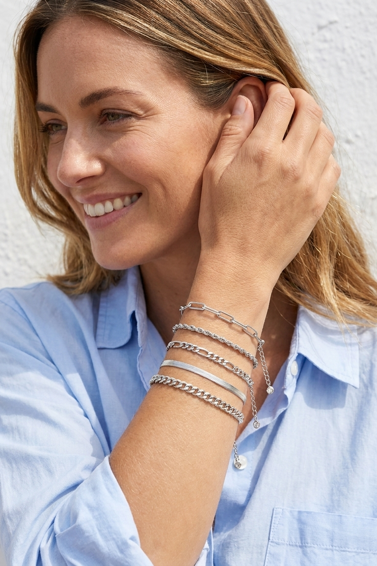 Woman wearing the silver Cinque bracelet stack in coastal daylight