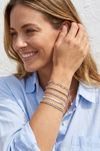 Woman wearing the silver Cinque bracelet stack in coastal daylight