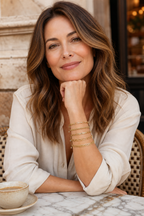 Woman at a cafe wearing the gold Cinque bracelet stack