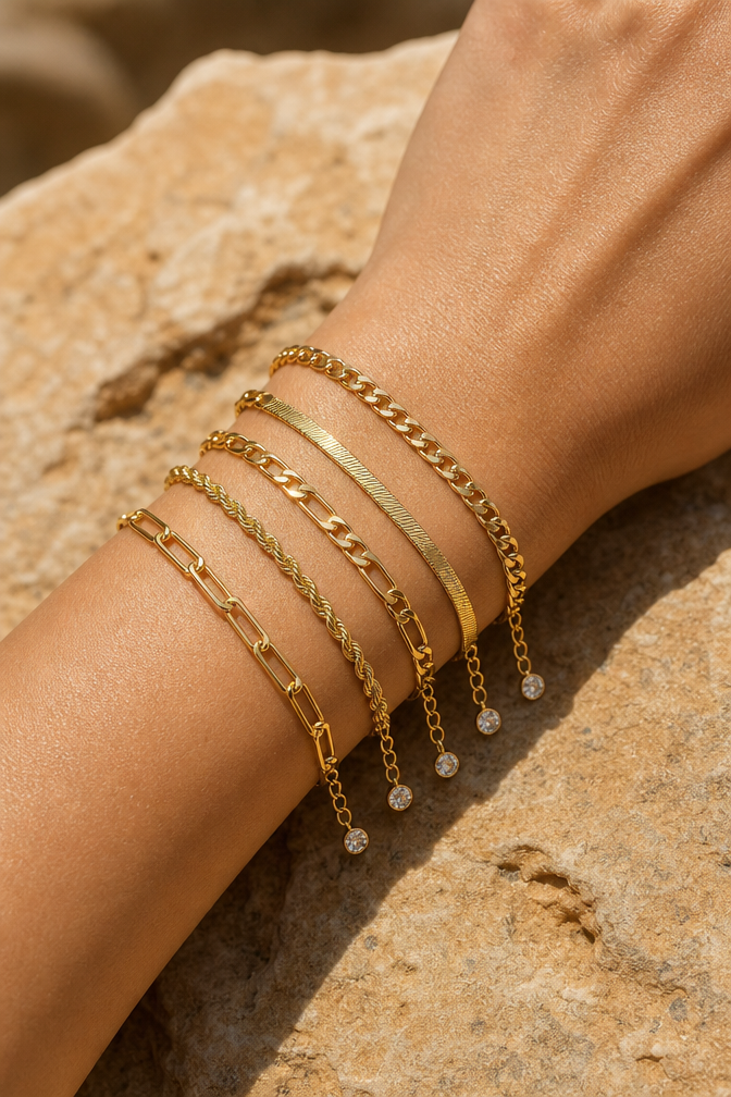 All five gold chain bracelets stacked on a wrist