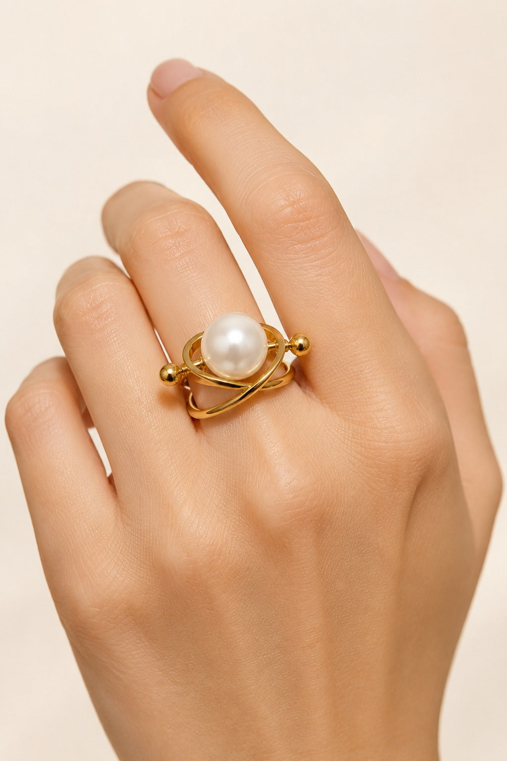 Atrani Orbit Ring worn on a hand against a cream backdrop