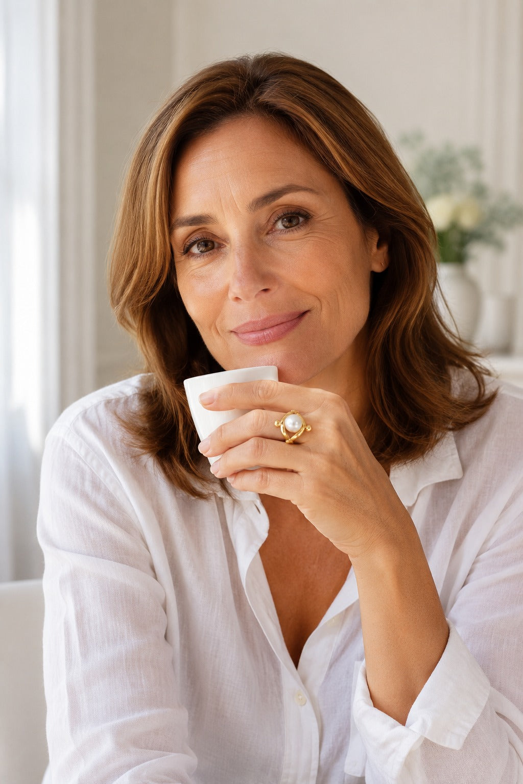 Woman holding an espresso cup wearing the Atrani Orbit Ring