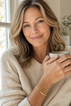 Woman with coffee wearing the Sei gold bracelet stack