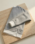 Bruma layered sweatshirt on warm travertine stone