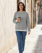 Woman wearing the Bruma layered sweatshirt with a white tee