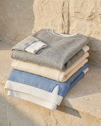 Bruma layered sweatshirt folded on a limestone ledge