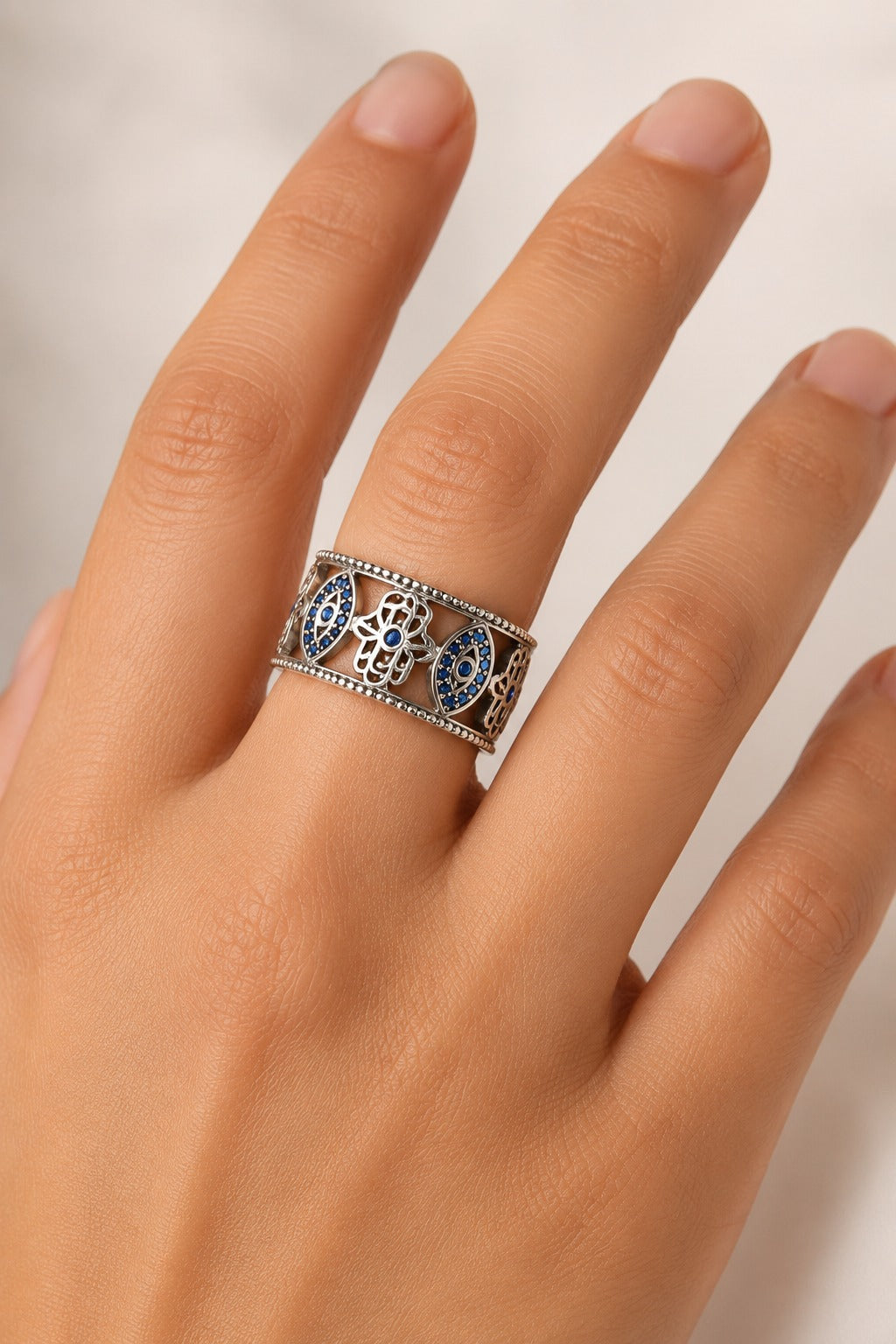 Cetara Evil Eye Ring worn on a hand against a cream backdrop