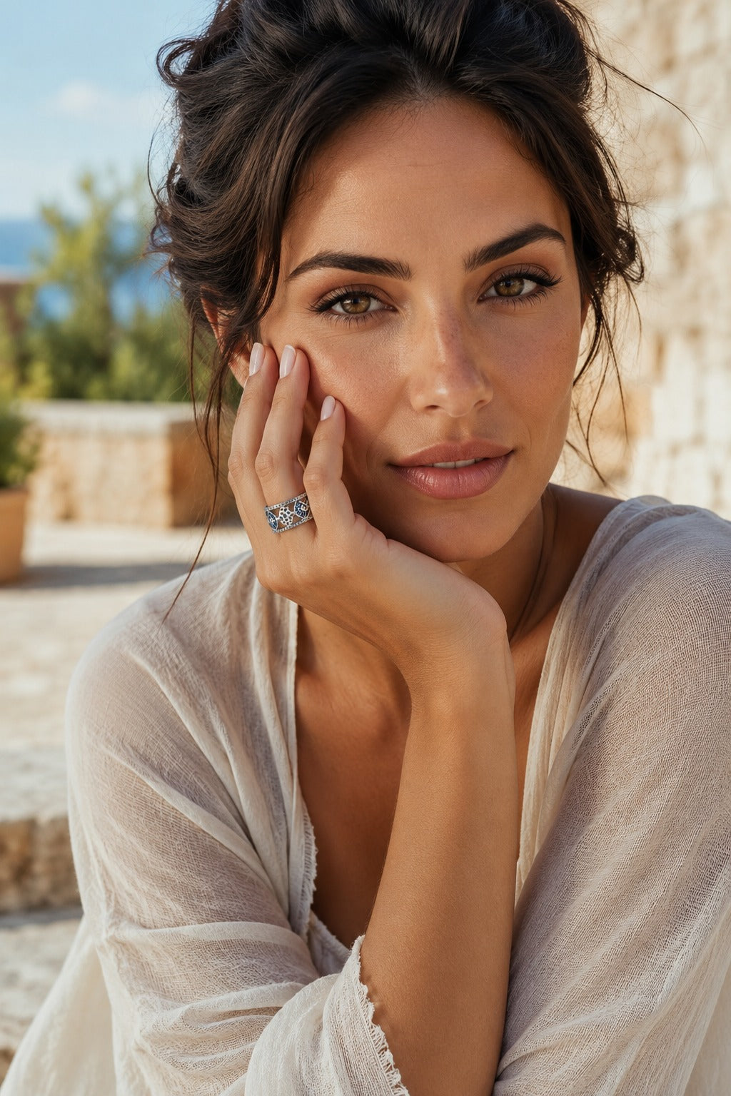 Woman resting her hand against her cheek wearing the Cetara Evil Eye Ring