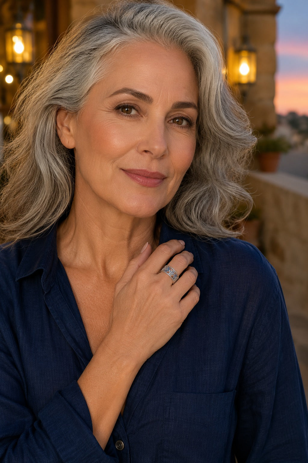 Woman in a navy linen shirt wearing the Cetara Evil Eye Ring at dusk