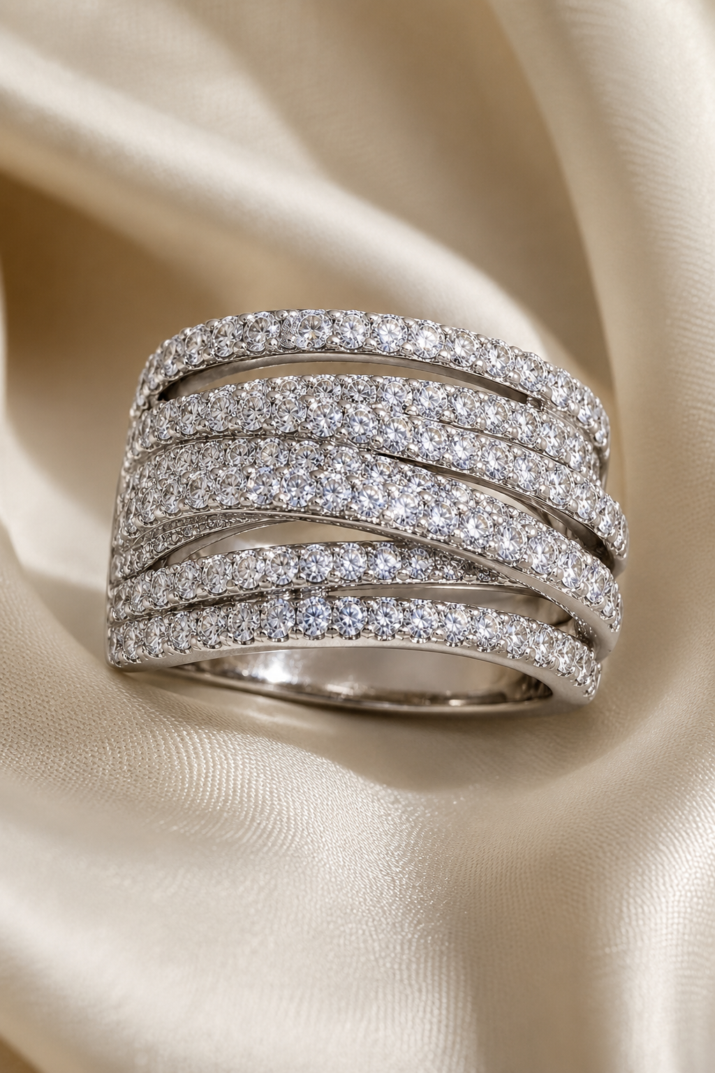 Abbraccio wide pave crossover ring resting on ivory silk