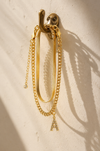 Marea anklet set hanging from a brass hook casting shadows