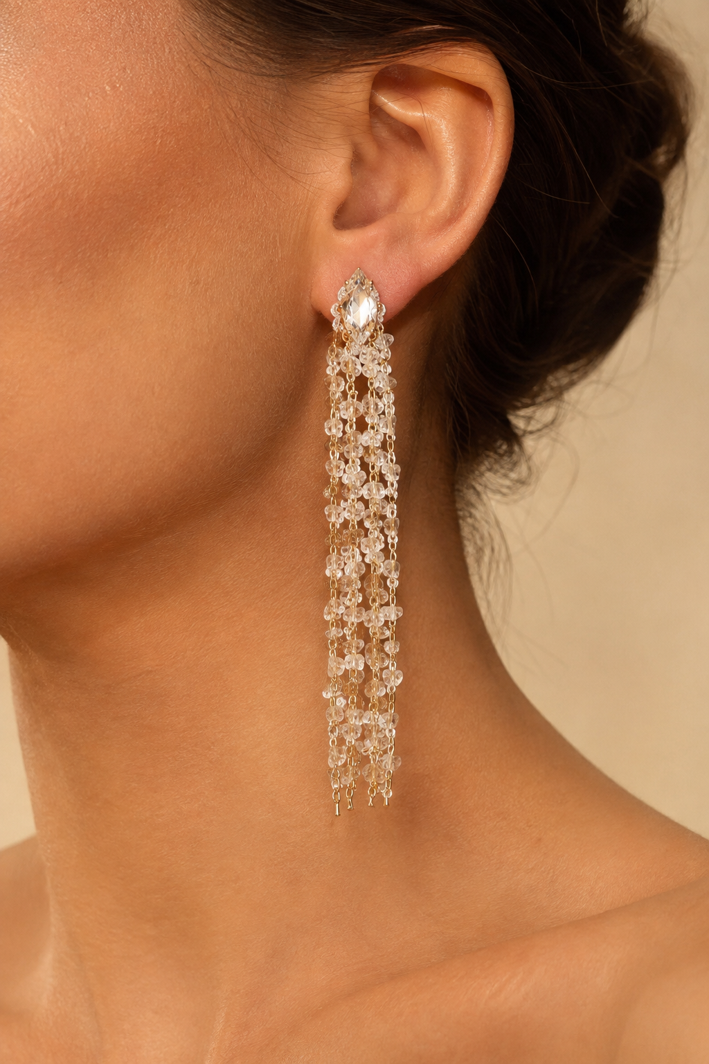 Close crop of the crystal topped tassel earring at the ear