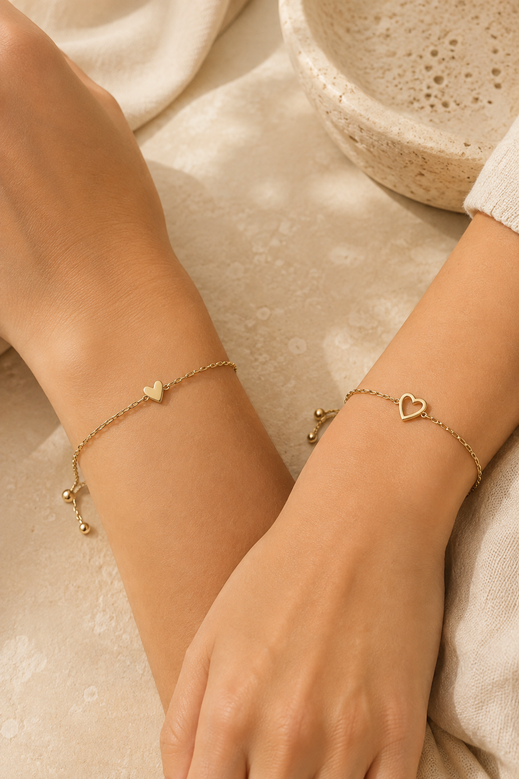 Two wrists wearing the matching heart bracelets