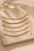 Cinque bracelet stack in gold on travertine stone