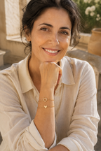 Woman wearing the solid heart bracelet on a sunlit terrace