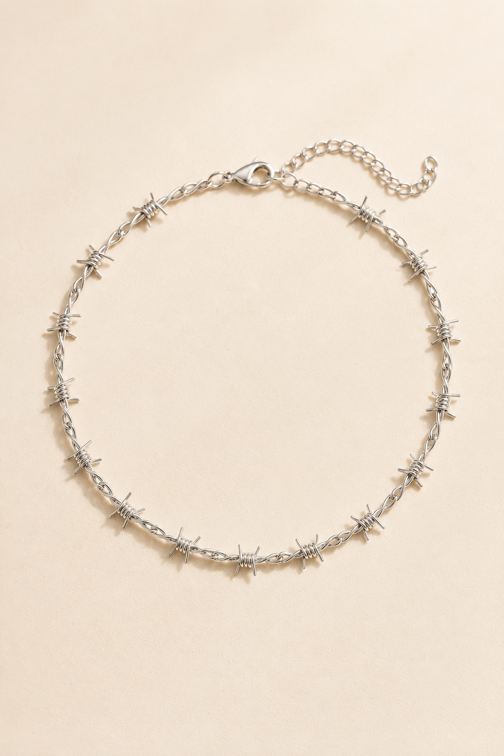 Spina barbed choker in silver on a cream background