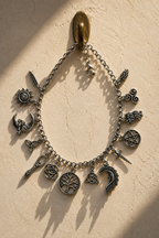 Incanto charm bracelet hanging from a brass hook casting evening shadows