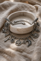 Incanto charm bracelet draped over a ceramic dish on linen