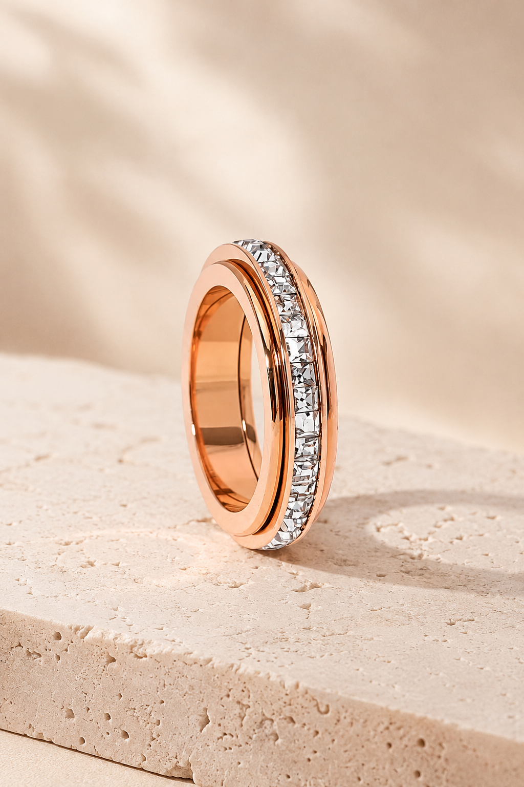Rose gold Calma spinner ring on blush travertine