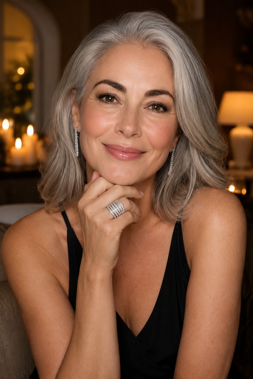 Woman with silver-grey hair in a black dress resting her chin on her hand, the Abbraccio ring sparkling