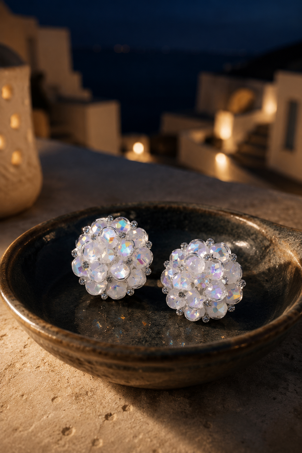 Ortensia crystal bloom studs in a dark ceramic dish by candlelight