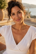 Woman in a white linen dress wearing the Stellina station necklace on a Mediterranean terrace