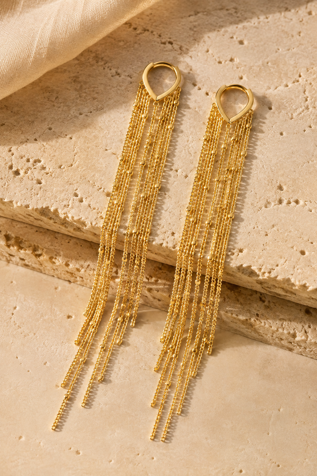 Cascata tassel earrings on travertine stone