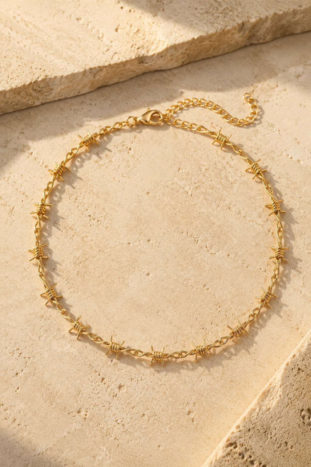 Spina barbed choker in gold on travertine stone