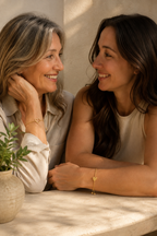 Two women wearing one bracelet each from the matching set