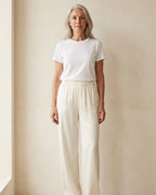 Woman wearing the Luna satin pant in ivory