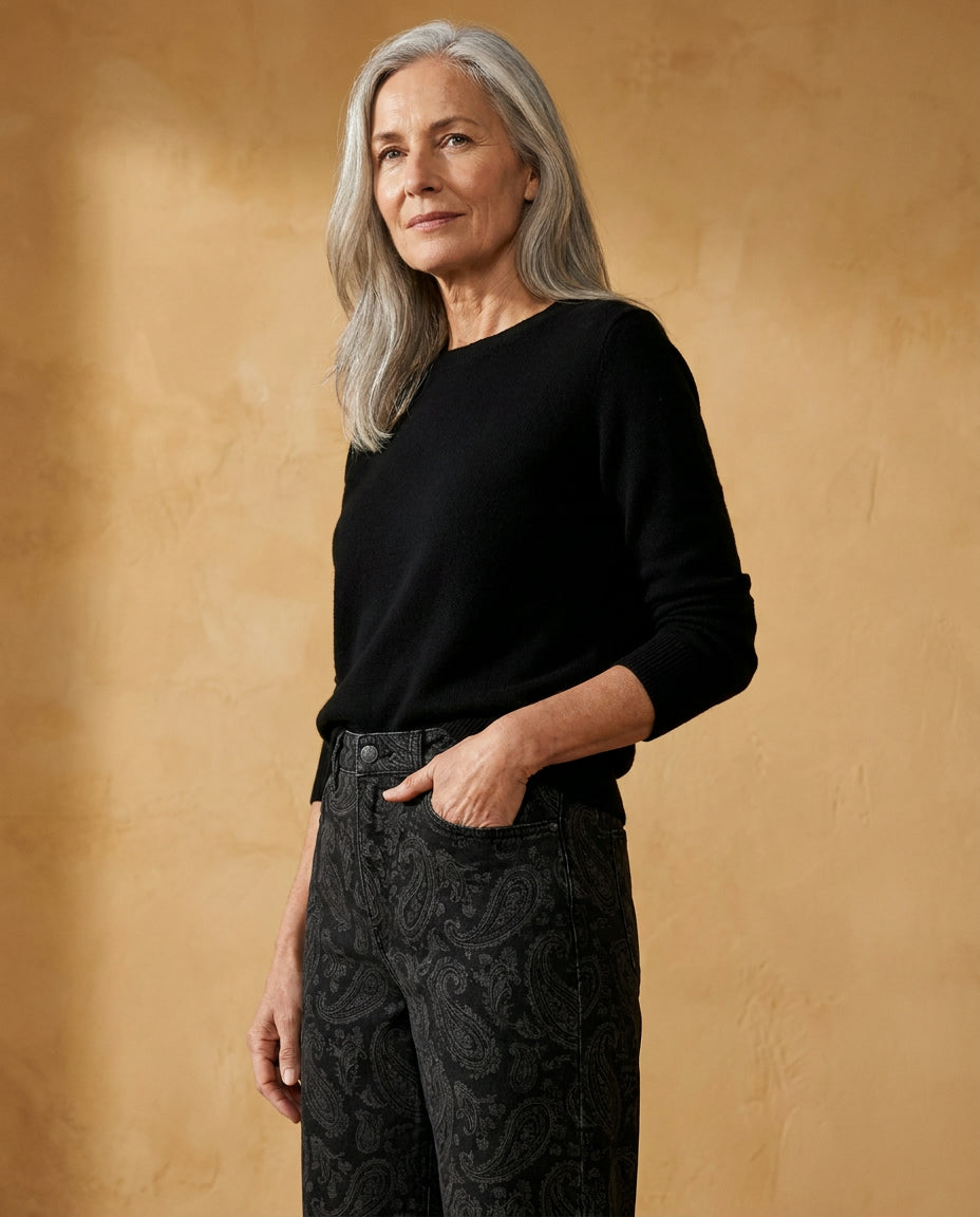 Woman wearing the Maiori barrel jean against an ochre wall