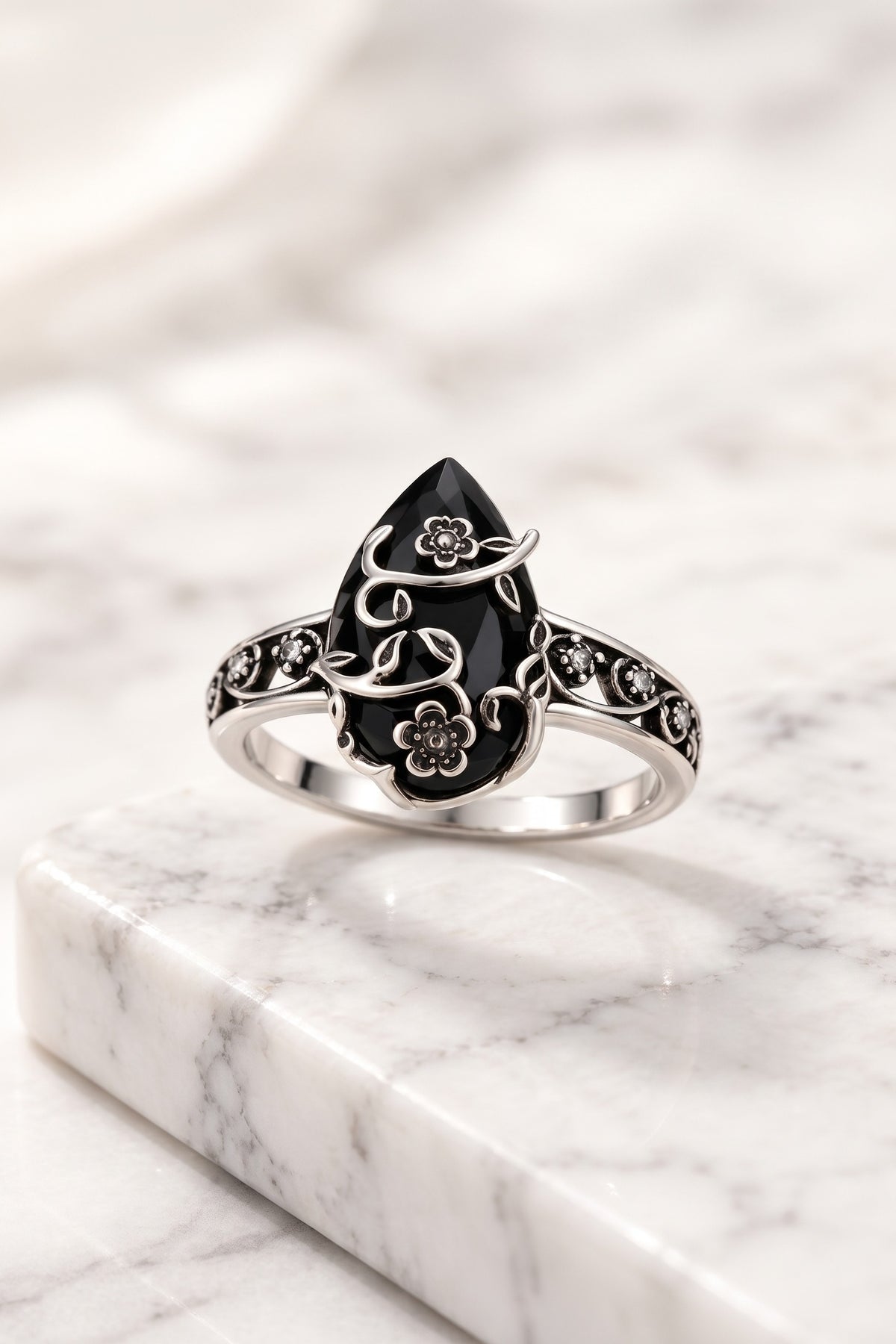 Ombra obsidian flower ring on white marble