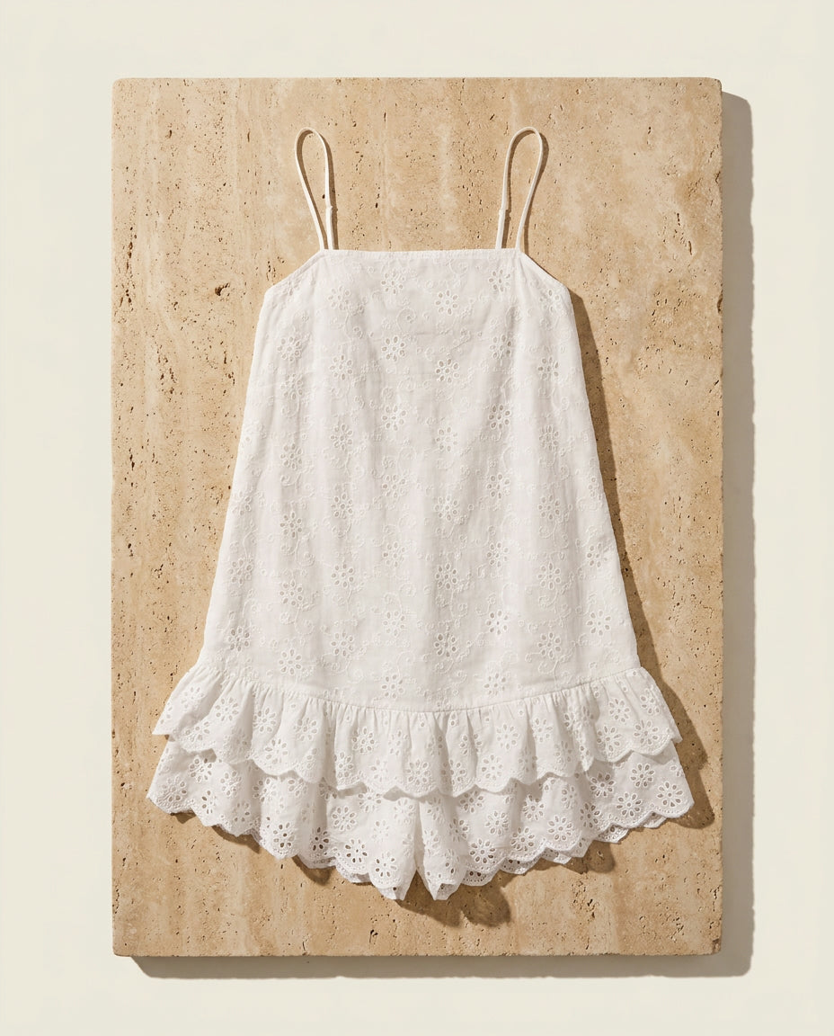 Praiano eyelet romper on warm travertine stone