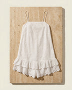 Praiano eyelet romper on warm travertine stone