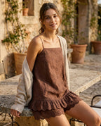 Woman wearing the Praiano eyelet romper on a terrace