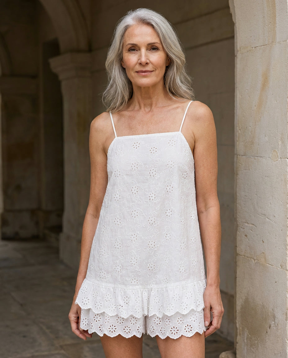 Woman wearing the Praiano eyelet romper in a cool doorway