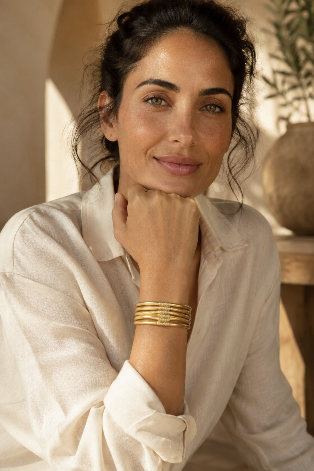 Woman wearing the Quiete bangle stack with a cream linen shirt