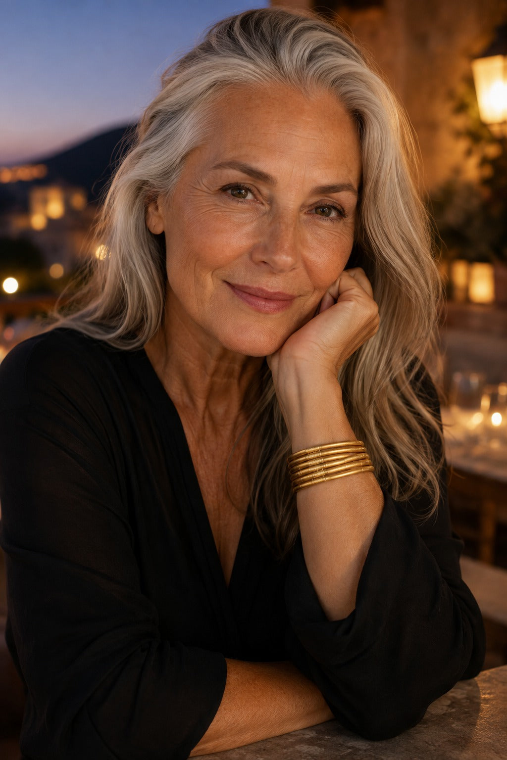 Woman with silver-grey hair wearing the Quiete bangle stack at dusk
