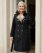 Woman wearing the Ravello trench coat in a stone doorway