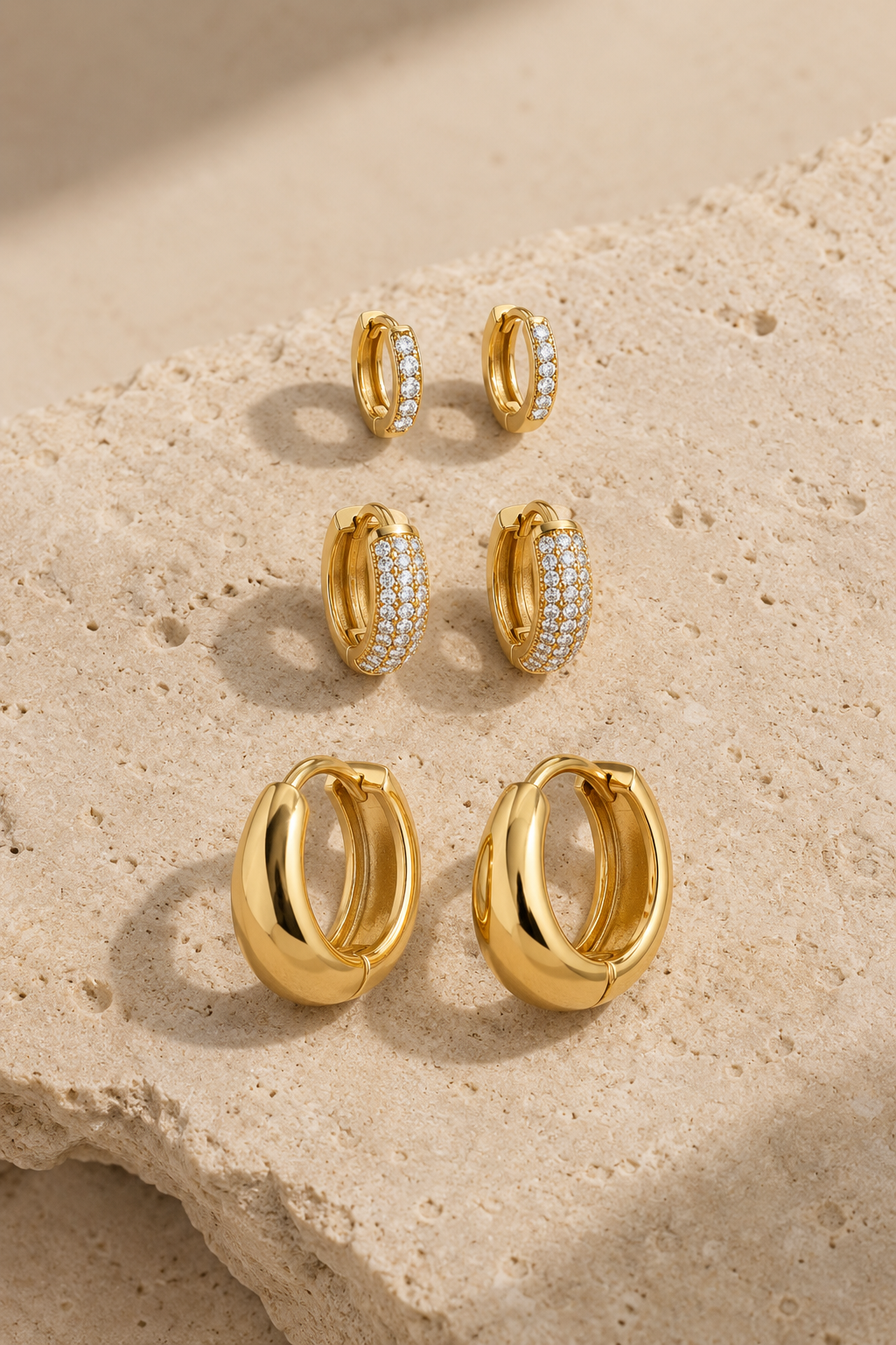 Scala hoop trio, three pairs of gold hoops on limestone