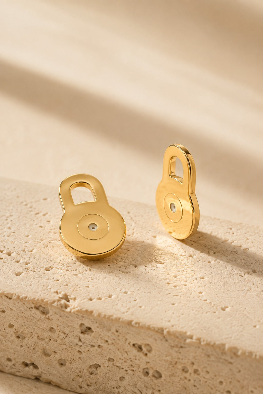 Solleva gold lobe lifter earring backs on warm travertine stone