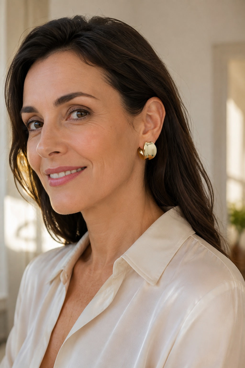 Woman wearing a gold stud sitting level on the lobe with Solleva backs